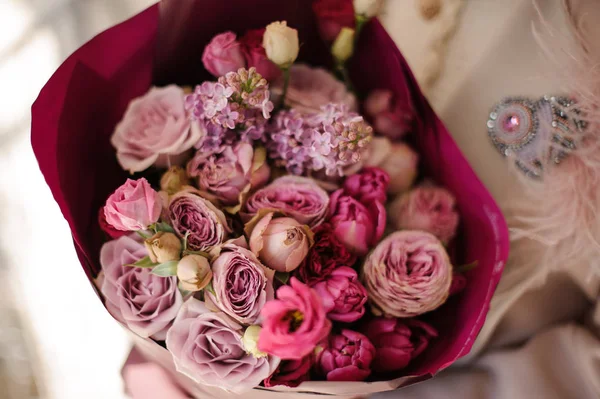 Fermer fille dans le manteau tenant un bouquet de fleurs violettes violettes — Photo