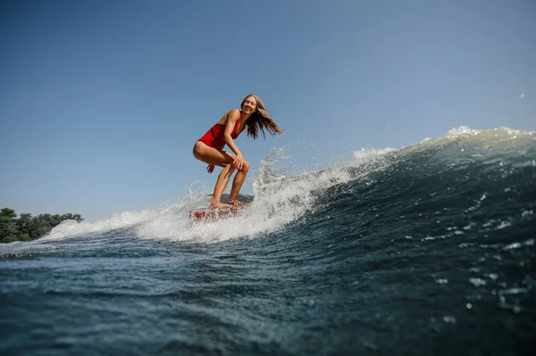 Femme aux cheveux longs surfe en mer — Photo