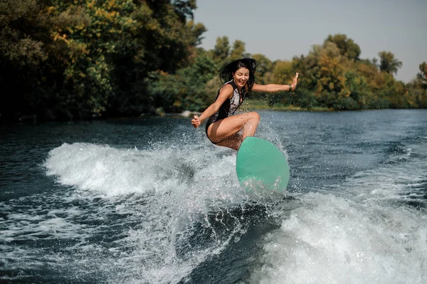 Surfgirl feliz en una tabla de surf cerca de la orilla del mar —  Fotos de Stock