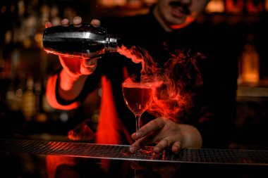 Profesyonel erkek barmen çelik shaker gelen kokteyl cam içine bir duman dökerek