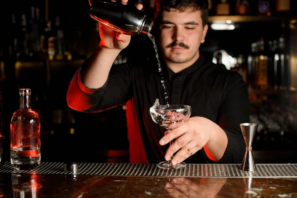 Professionele barman gieten een transparante alcohol in de cocktail glas van de stalen Shaker — Stockfoto