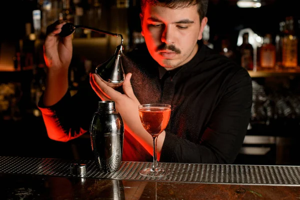 Professionele mannelijke barman spuiten uit de diffuser op de heerlijke cocktail in het glas — Stockfoto