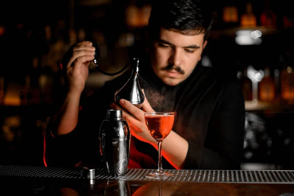 Profissional barman masculino pulverização do difusor no coquetel no vidro — Fotografia de Stock