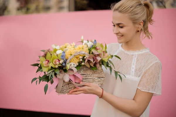 Счастливая девушка с букетом в цветочной корзине — стоковое фото