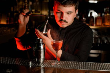 Barmen bir kokteyl yapmak için pulverizer kullanarak