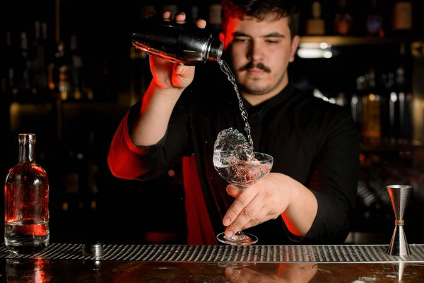 Cantinero prepara una bebida alcohólica con coctelera — Foto de Stock