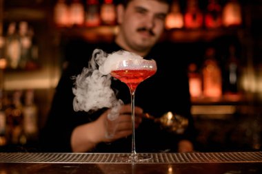 Barmen bir alkol içeceği köpük koyarak