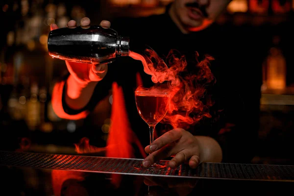 Barman derramando coquetel de álcool fumegante com agitador — Fotografia de Stock