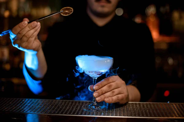 Barman voegt citroen slice in alcohol cocktail — Stockfoto