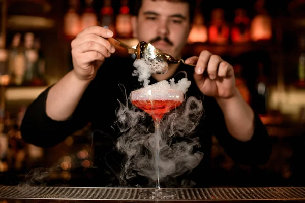 Barman het toevoegen van schuim in een alcohol drinken — Stockfoto