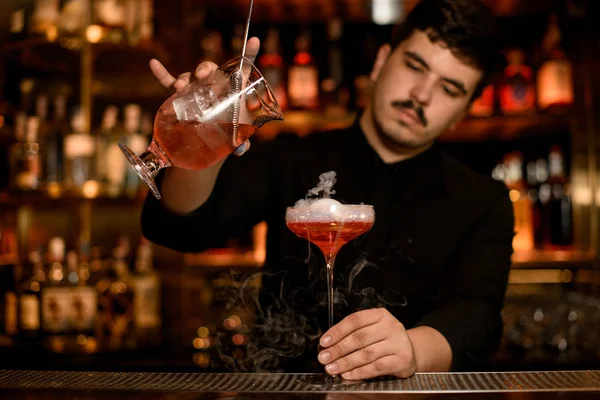 Barkeeper mit Sieb bereitet ein Alkoholgetränk zu — Stockfoto