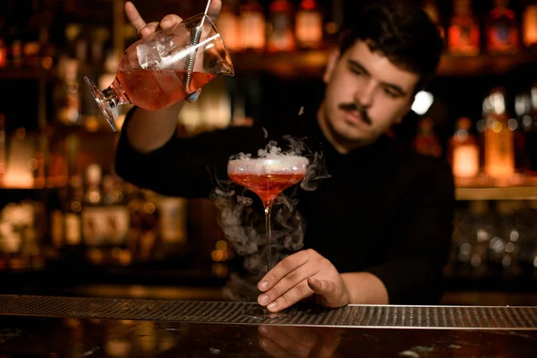 Cantinero con colador preparando una bebida alcohólica — Foto de Stock