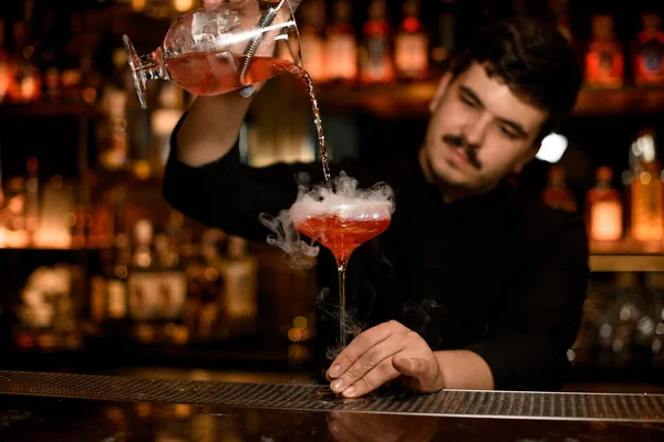 Barman met zeef bereidt een alcohol cocktail voor — Stockfoto