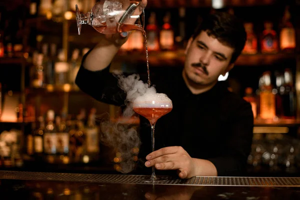 Barmen bir alkol kokteyl hazırlamak için süzgeç kullanır — Stok fotoğraf