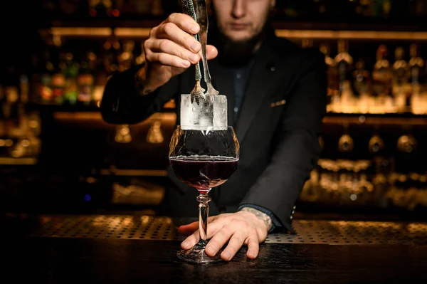 Barista mettere grande cubetto di ghiaccio in un cocktail — Foto Stock