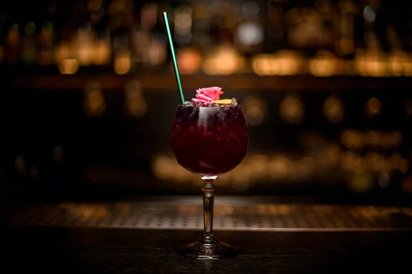 Close shot de bebida alcoólica com flor, raspas de limão e palha — Fotografia de Stock