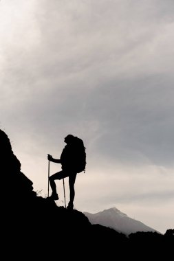 Dağa tırmanan kadın yürüyüşçü silueti