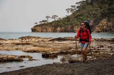 Sırt çantası ile kadın bir deniz kıyısında seyahat