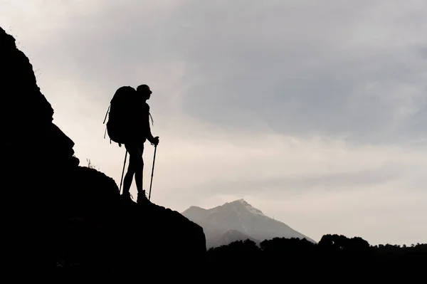 Силуэт женщины-туриста, стоящей на горе — стоковое фото