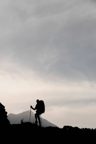 Silhouette of female hiker posing on top of mountain