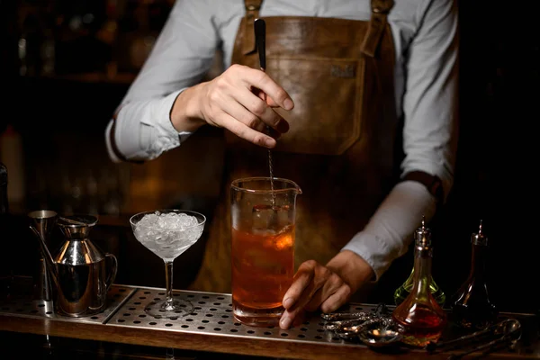 Barista mescolando un delizioso cocktail nella tazza di vetro di misurazione — Foto Stock