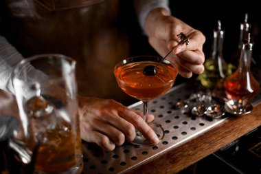 Erkek barmen kokteyl bardağıüzerinde şiş üzerine berry koyarak