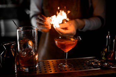 Barmen kokteyl bardağına çakmaktan ateş koyarak