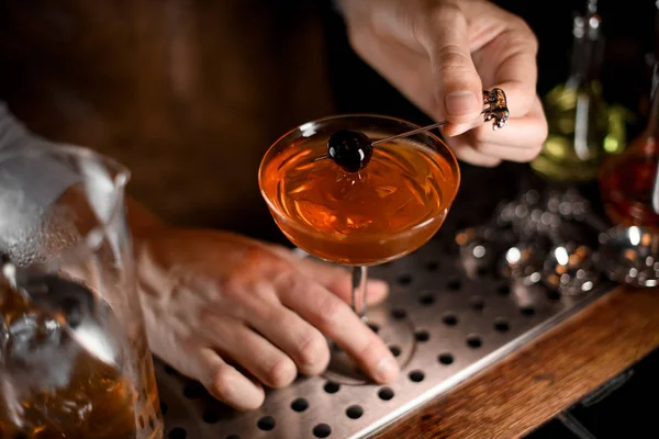 Barman profissional colocando baga no espeto no copo de coquetel — Fotografia de Stock