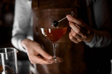 Şiş te dutla süslenmiş camda kokteyl servisi yapan barmen