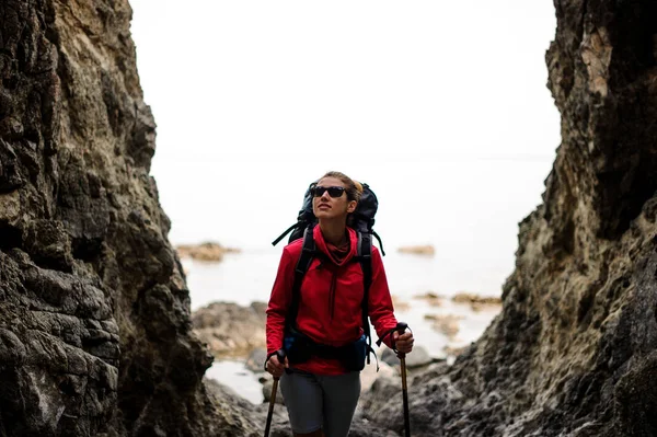 Жіночий пішохід з рюкзаком, що стоїть між скелями — стокове фото