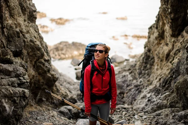 Жіночий пішохід з рюкзаком стоїть між скелями — стокове фото
