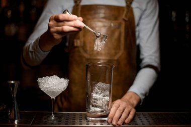 Erkek barmen ölçüm cam fincan bir buz küpü koyarak