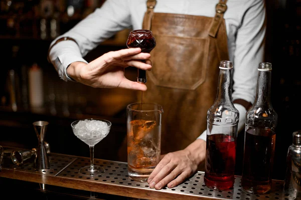 Barkeeper fügt eine Essenz aus der kleinen Glasflasche hinzu — Stockfoto