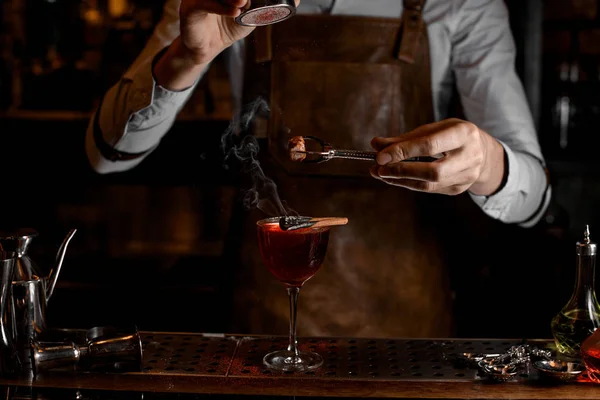 Bartender adicionar especiarias para uma decoração acima de um delicioso coquetel vermelho no copo — Fotografia de Stock