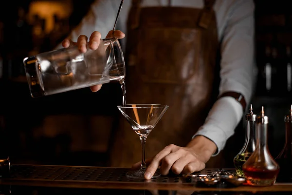 Bartender hälla en alkoholhaltig dryck från mätglaset till martini glas — Stockfoto