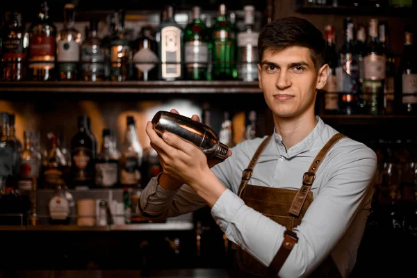 Atraente barman masculino segurando em mãos um agitador de aço — Fotografia de Stock