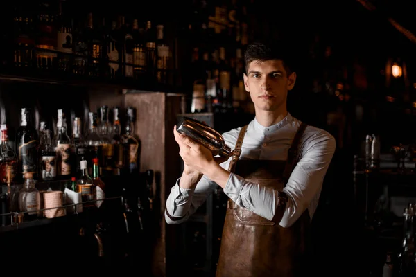 Barman profissional segurando nas mãos uma coqueteleira de aço — Fotografia de Stock