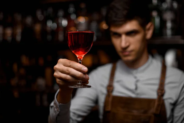 Atraktivní barman nabízející rudý alkoholický koktejl ve skle — Stock fotografie