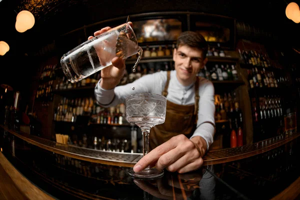 Fisheye tiro atraente barman masculino derramando um coquetel do copo de medição para o vidro — Fotografia de Stock