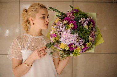 İhale yeşil, sarı ve menekşe çiçekler bir bahar buket tutan kız