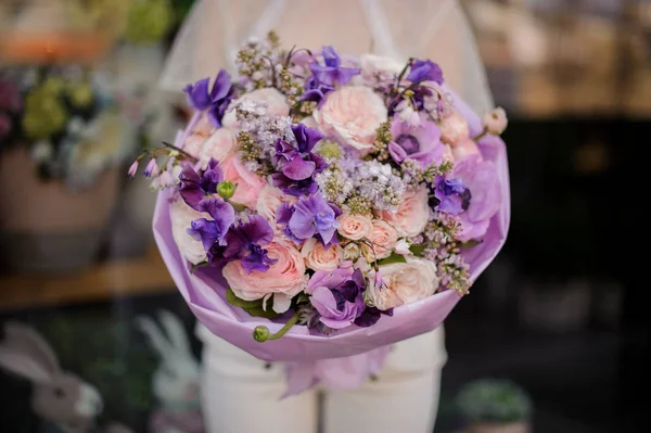 Ragazza che tiene un mazzo di fiori viola e teneri di colore rosa — Foto Stock