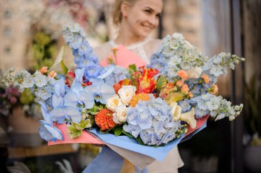 Kız ihale açık mavi ve turuncu renk çiçekler büyük bir buket tutan