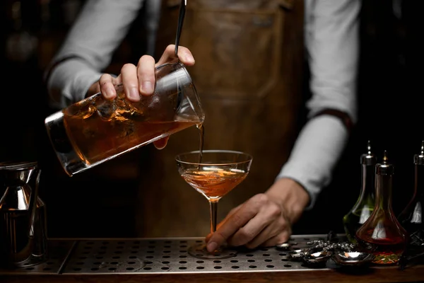 Bartender hälla alkohol cocktail med en sil — Stockfoto