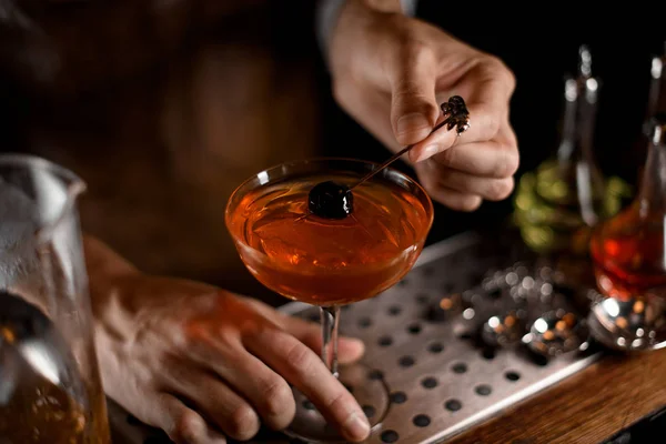 Barman colocando azeitona em vidro com coquetel — Fotografia de Stock