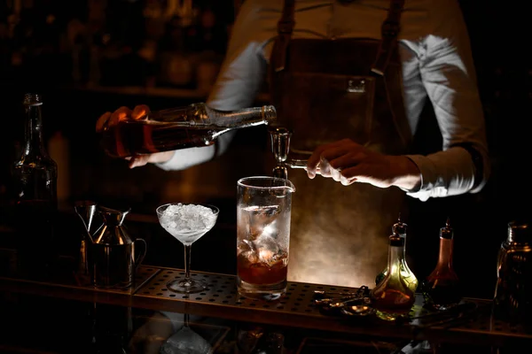 BarTender przygotowuje koktajl alkoholowy za pomocą Jigger z uchwytem — Zdjęcie stockowe