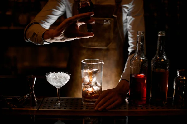 Bartender pouring cocktail from vial in glass — Stock Photo, Image