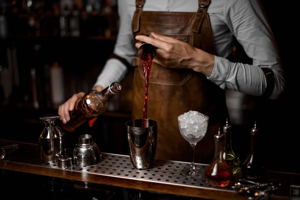 Bartender pours cocktail from jigger to shaker — Stock Photo, Image