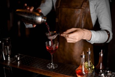 Barmen cam içinde elek ile kokteyl dökme