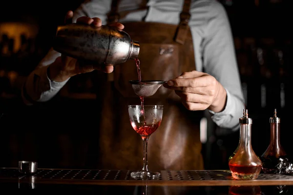 Bartender coquetel fluindo através da peneira em vidro — Fotografia de Stock