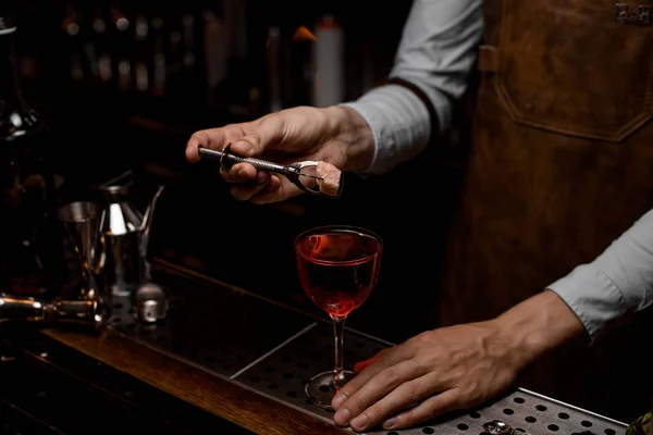 Barman houdt brandende suiker boven alcohol cocktail — Stockfoto